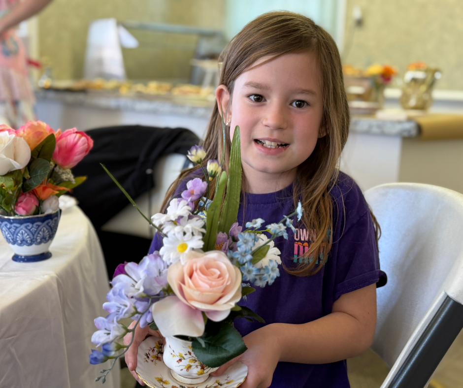 River Radke, age 8, shows off the teacup bouquet she made.